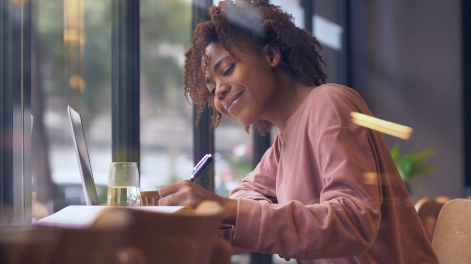 Afroamerican-woman-writing-letter-on-her-desk-personal-reason-leave