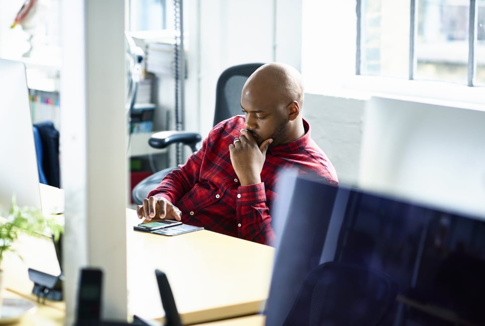 Bored-man-text-messaging-at-desk-why-am-i-so-tired-all-the-time