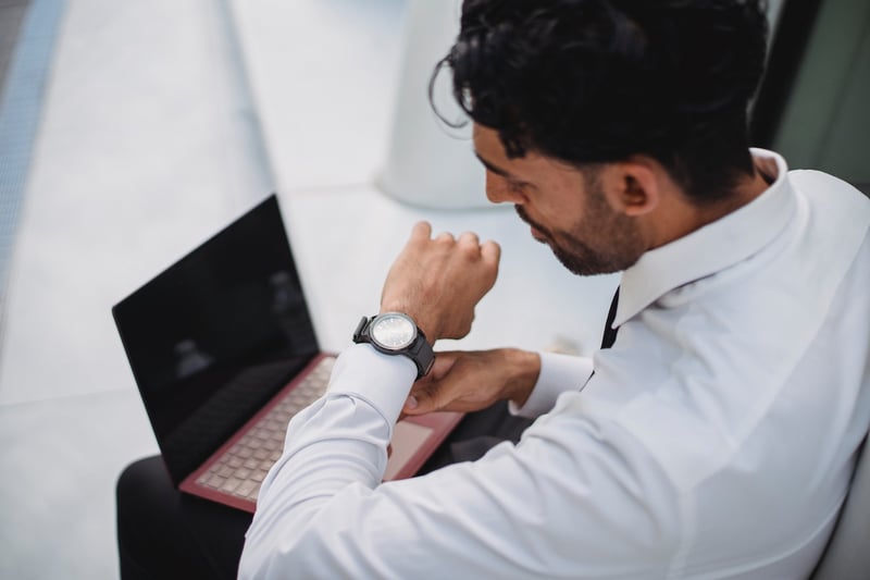 Business-man-looking-at-his-watch-how-to-send-a-reminder-email