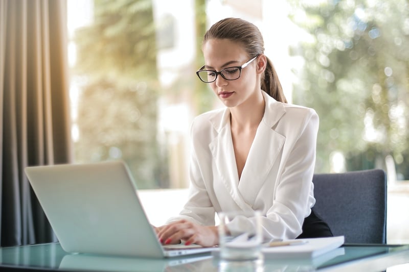 Business-woman-writing-on-her-laptop-how-to-send-a-reminder-email