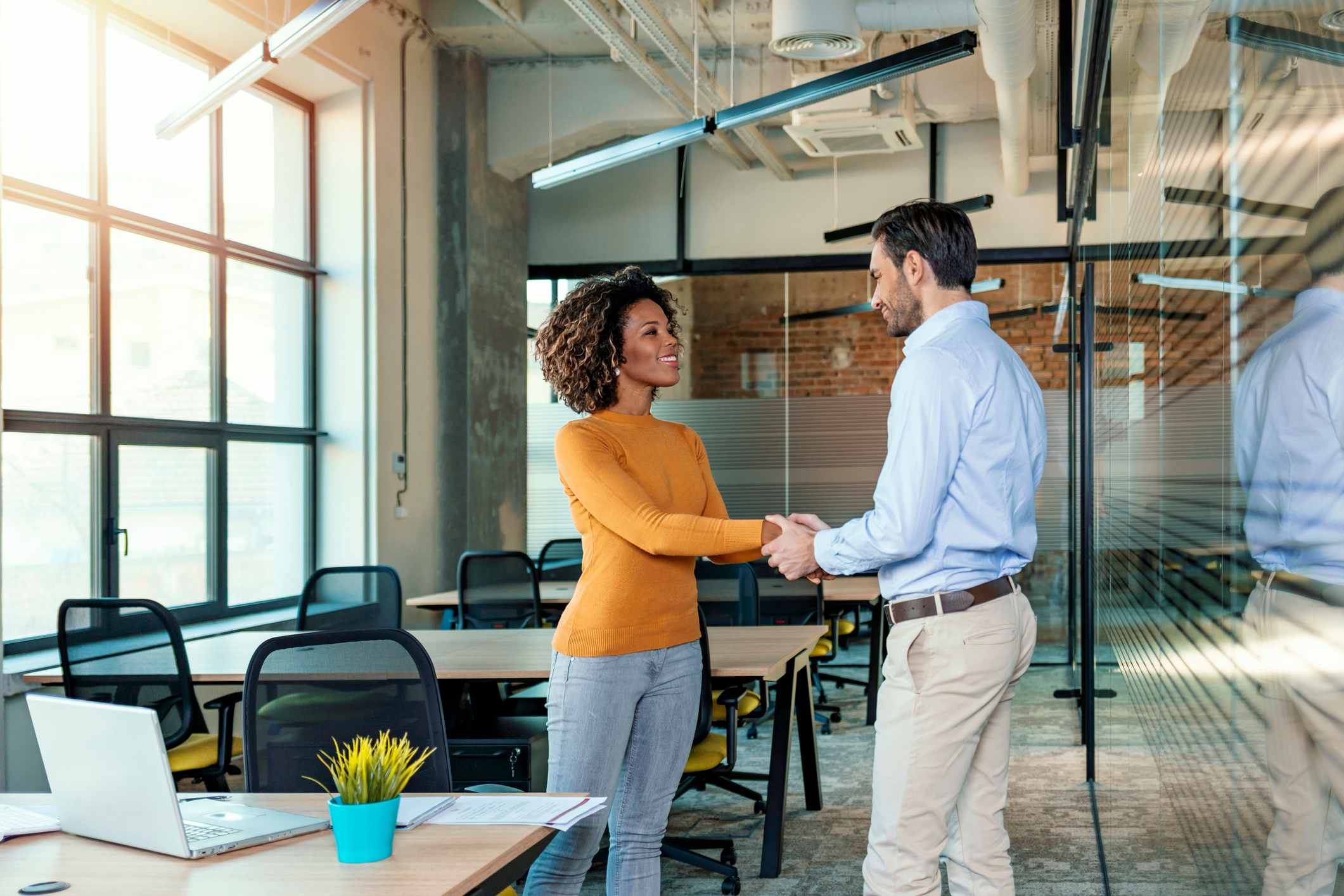 Businessman-And-Businesswoman-Shaking-Hands-In-Office-while-standing-what-is-commission-pay