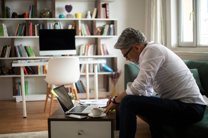 Businessman-writing-on-his-calendar-at-home-examples-of-behavioral-goals