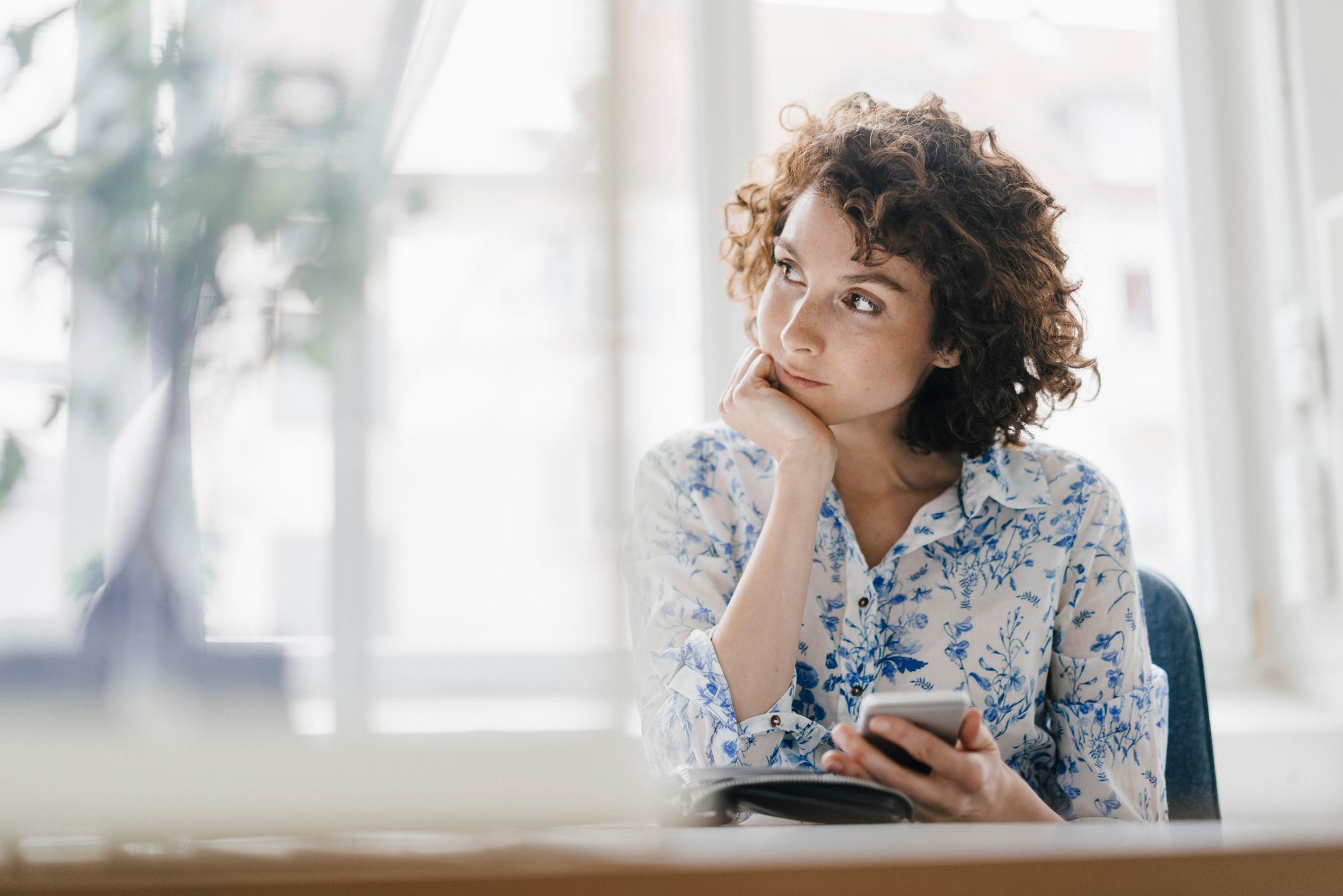 Businesswoman-in-office-with-smartphone-and-diary-how-improving-your-concentration-helps-your-memory