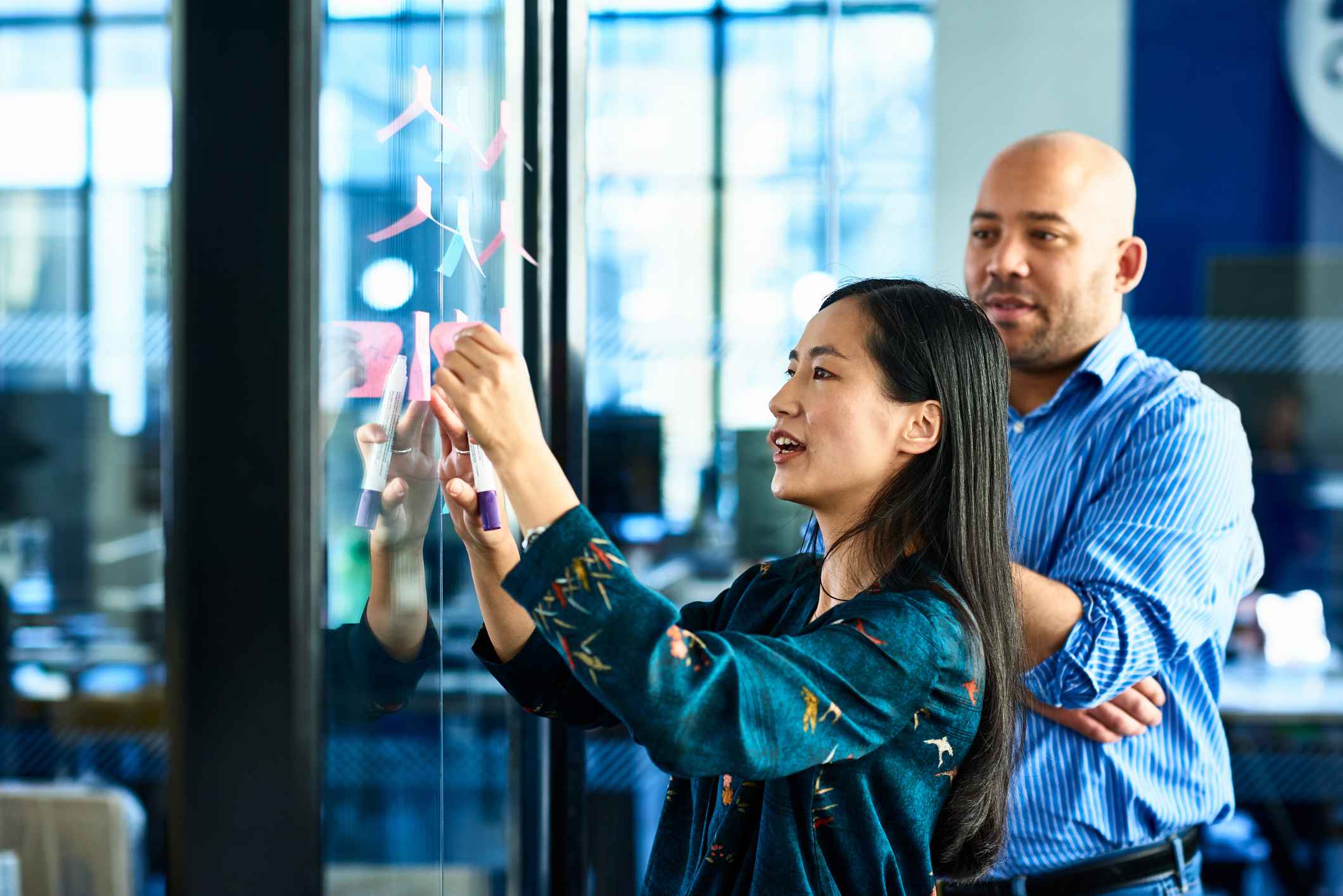 Businesswoman-sticking-notes-on-glass-building-influence-without-authority