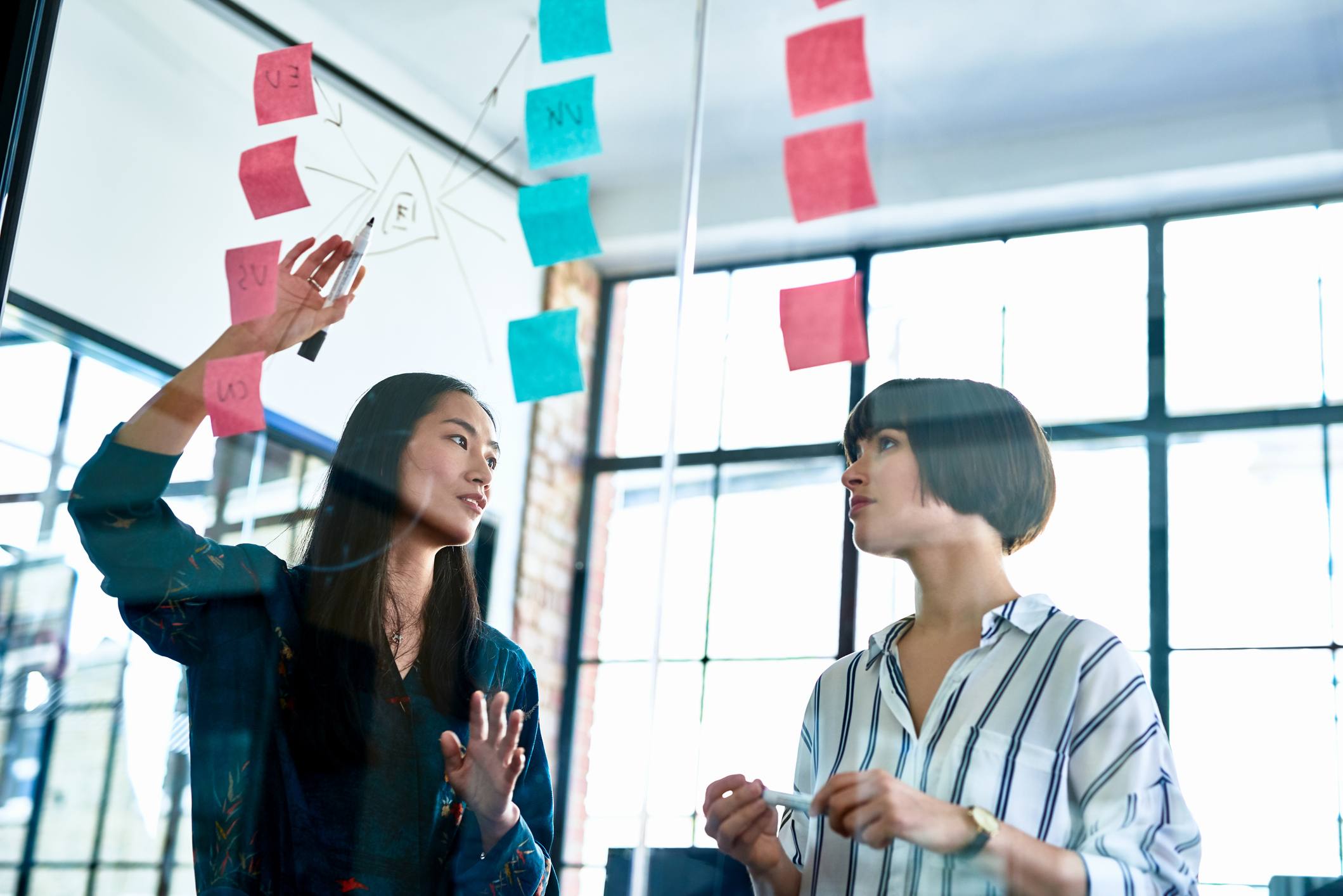 Chinese-woman-standing-behind-glass-how-to-make-an-action-plan-to-achieve-goals