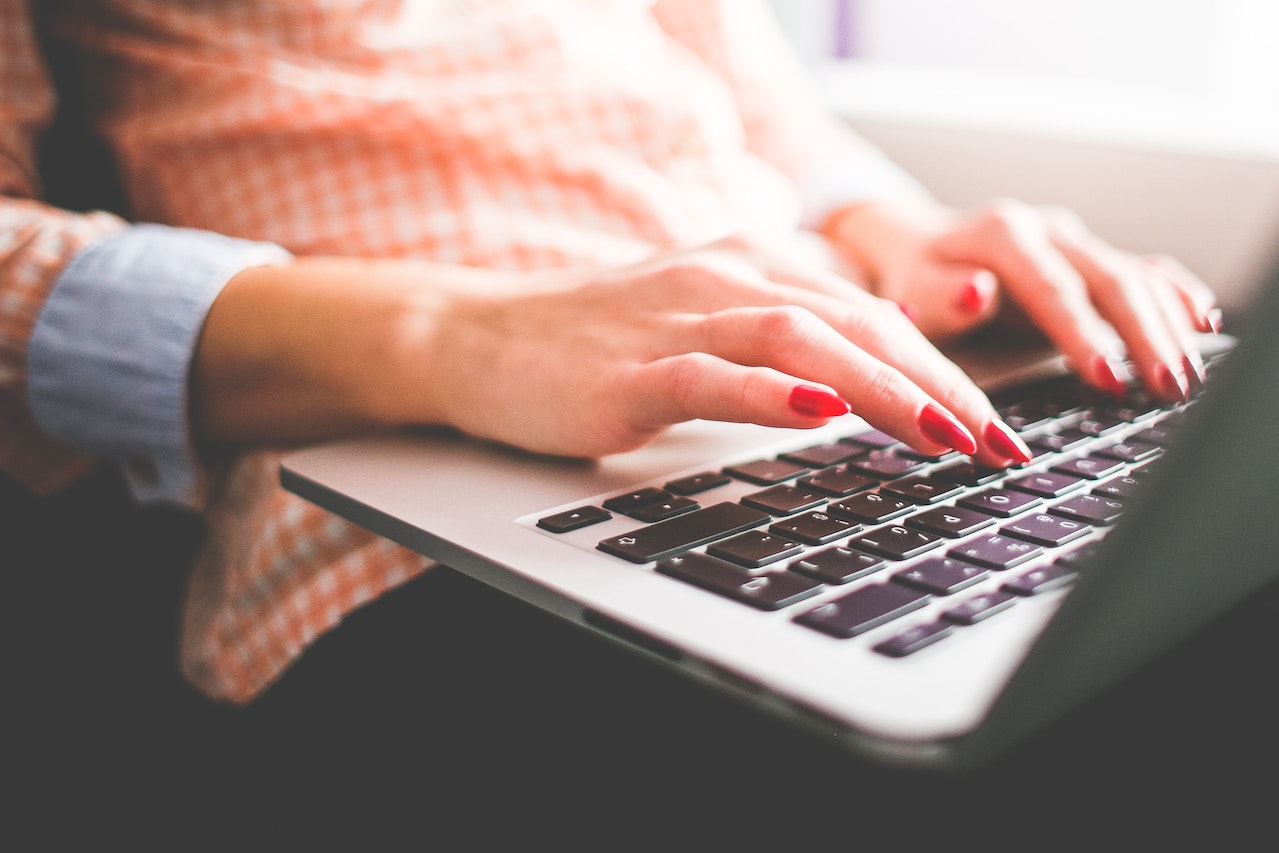 Close-up-of-womans-hand-writing-on-her-laptop-how-to-message-a-recruiter-on-LinkedIn
