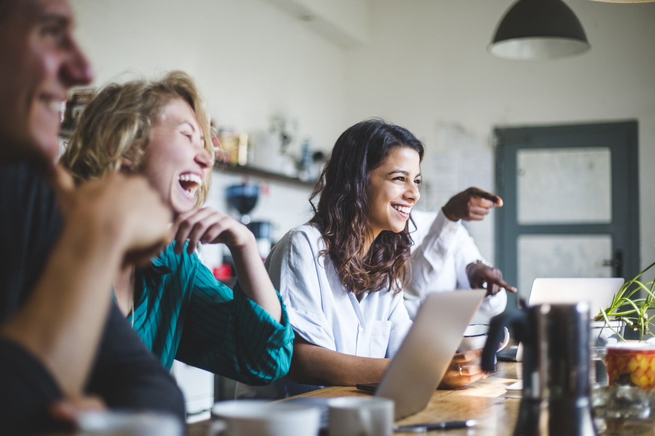 Confident-cheerful-IT-professionals-sitting-at-table-while-working-in-creative-office-factors-that-promote-resilience
