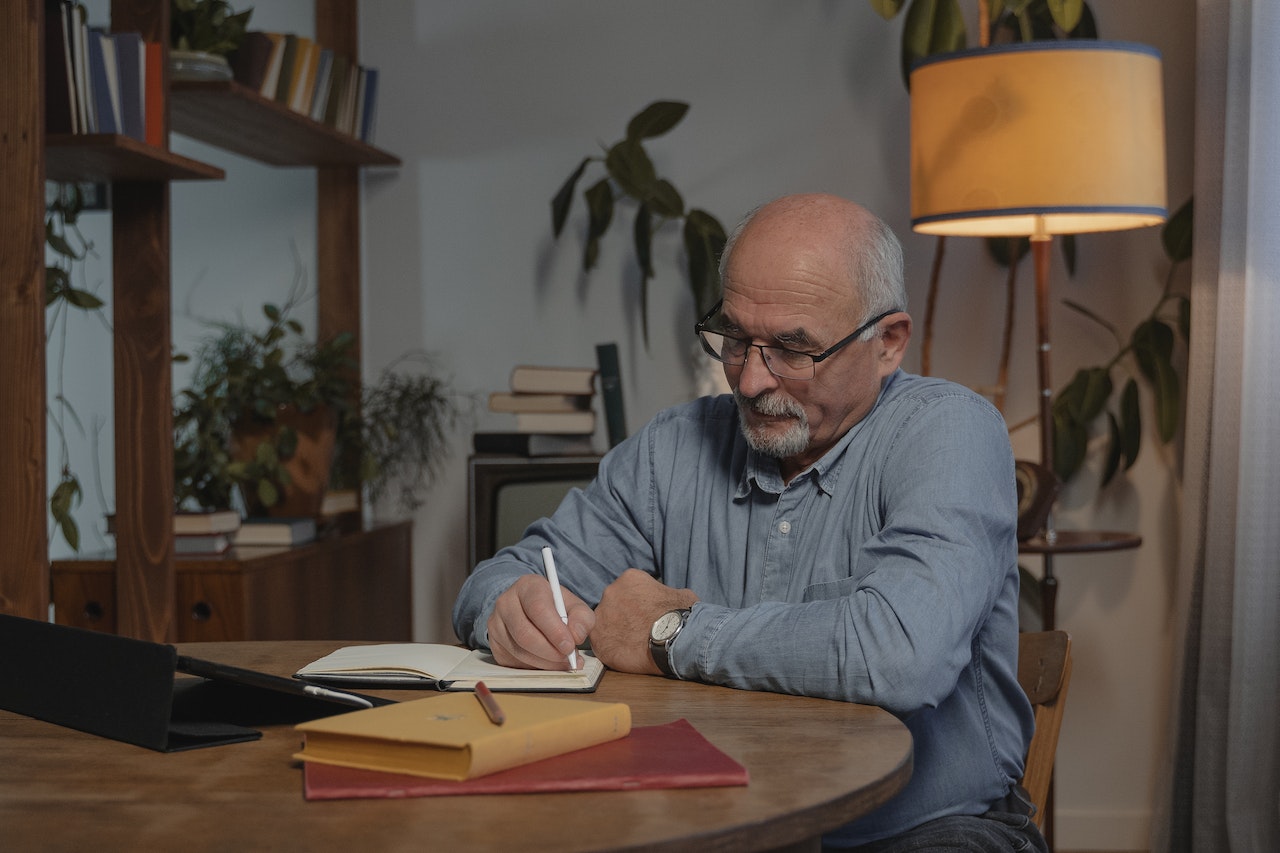 Elderly-man-writing-on-his-journal-at-night-words-to-describe-yourself