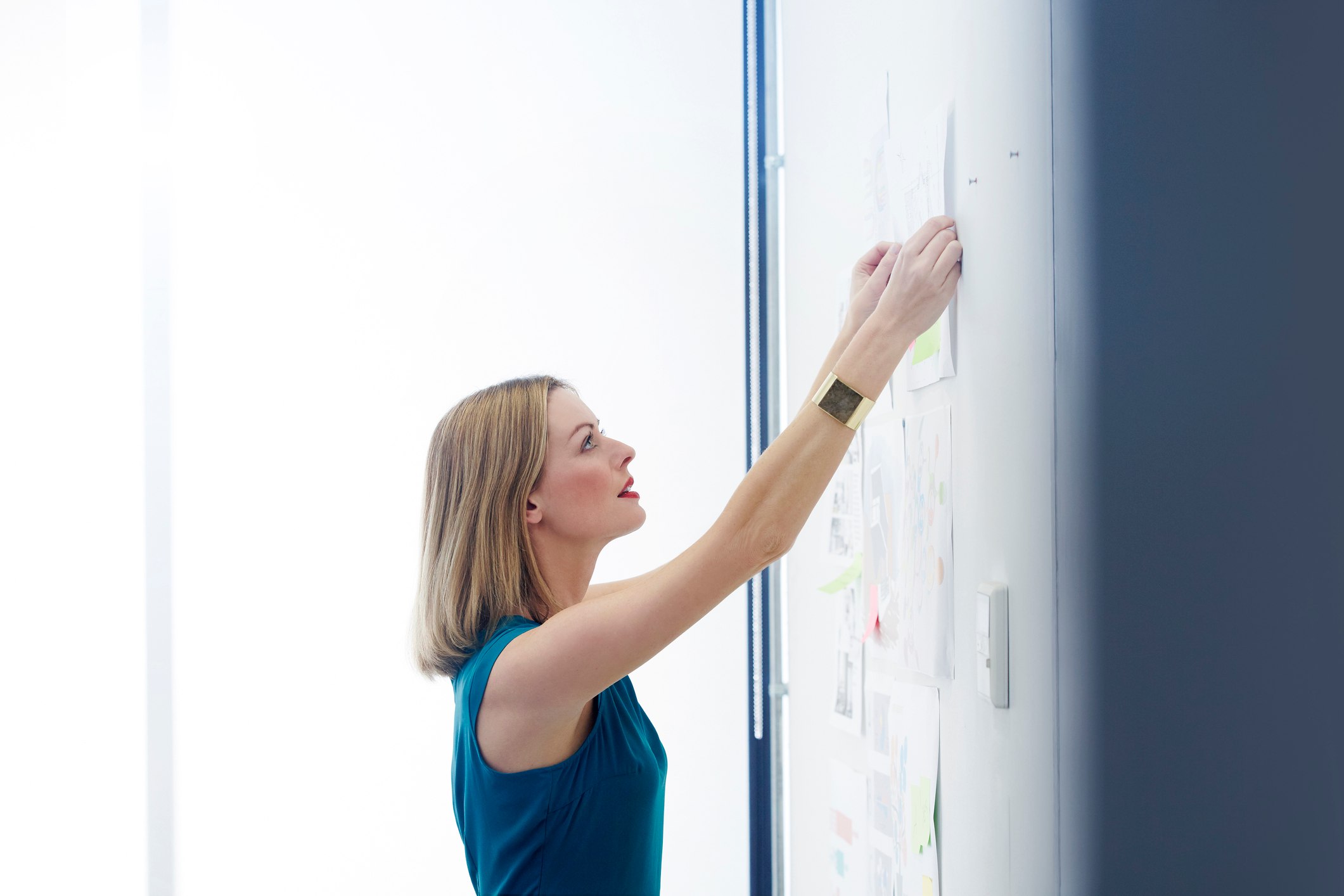 Female-colleague-pinning-up-work-for-brainstorm-how-to-write-a-letter-of-recommendation