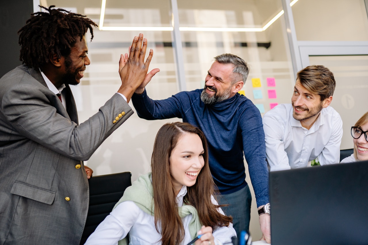 Happy-group-of-coworkers-doing-high-five-relational-leadership-model