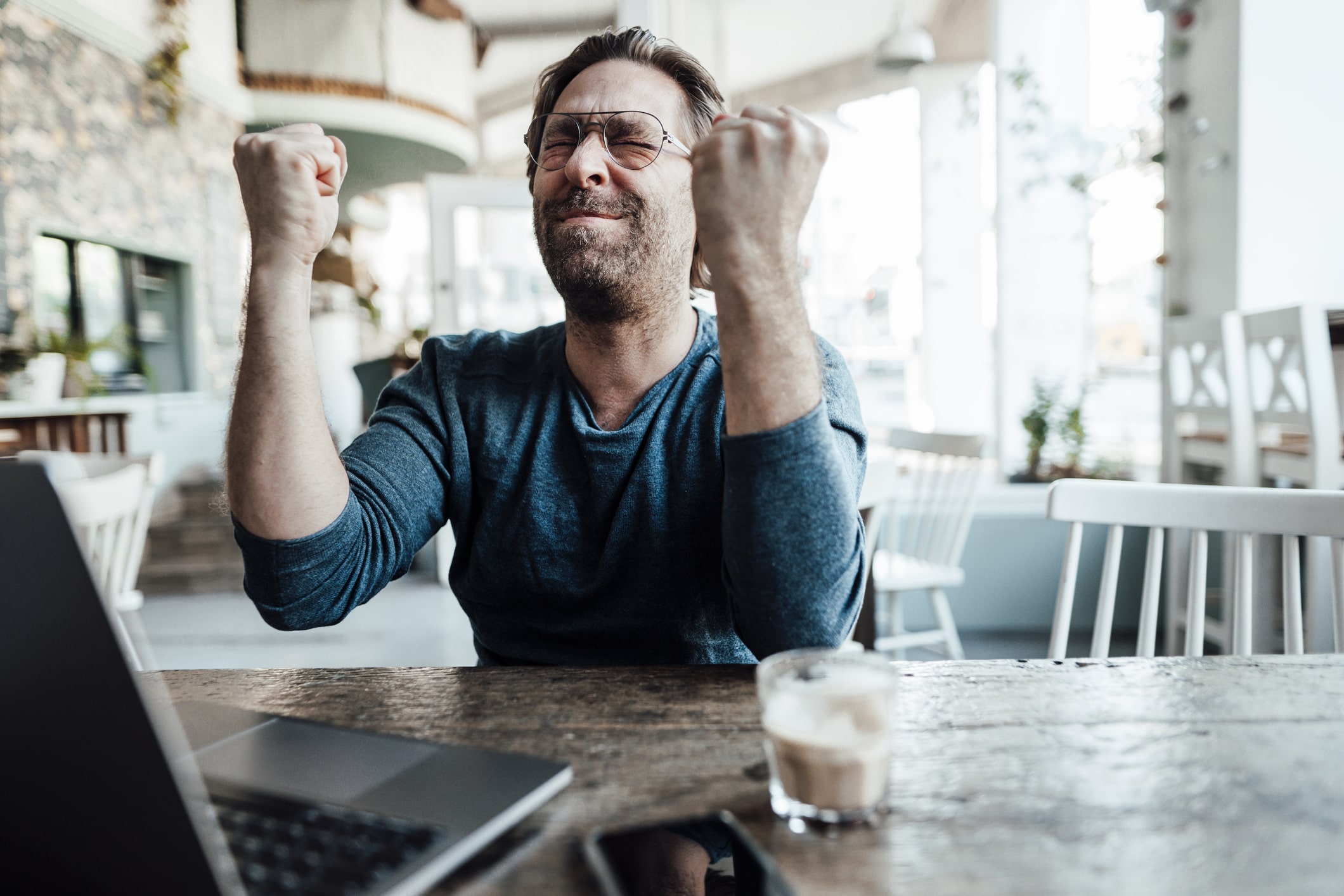 Happy-male-entrepreneur-doing-fist-by-laptop-in-coffee-shop-types-of-goals