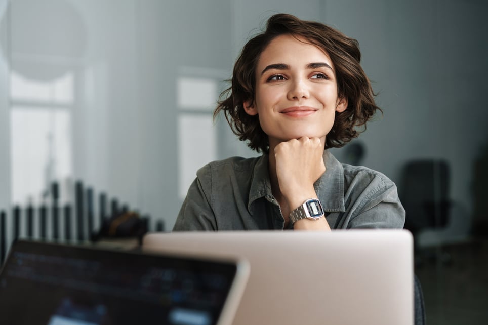Happy-woman-smiling-in-front-of-laptop-how-to-be-ambitious