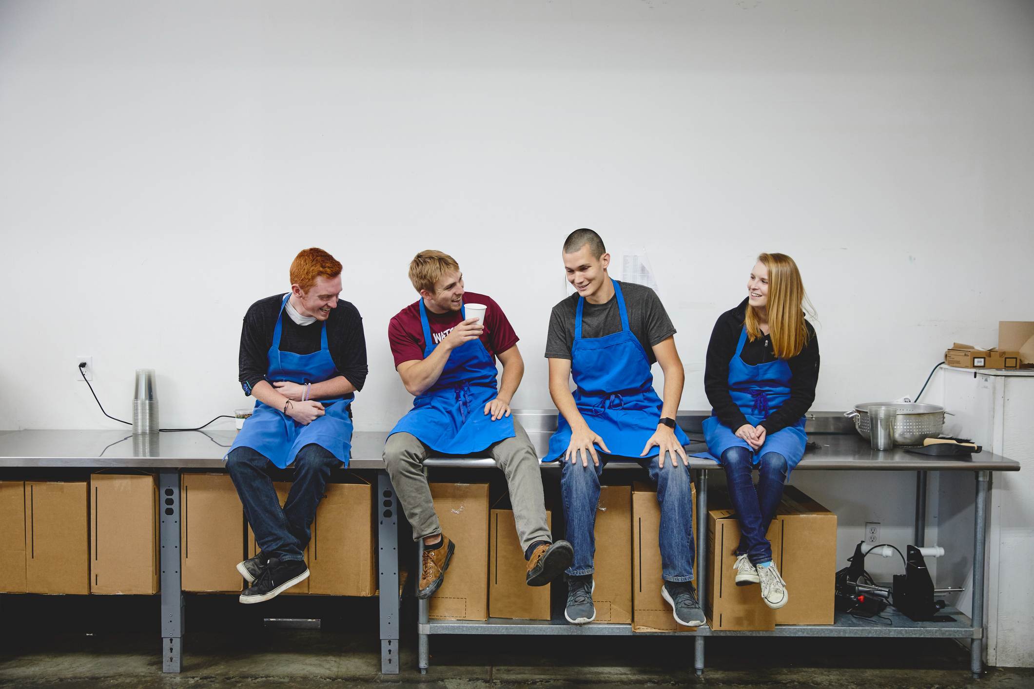 Happy-workers-talking-while-sitting-on-table-the-importance-of-taking-breaks