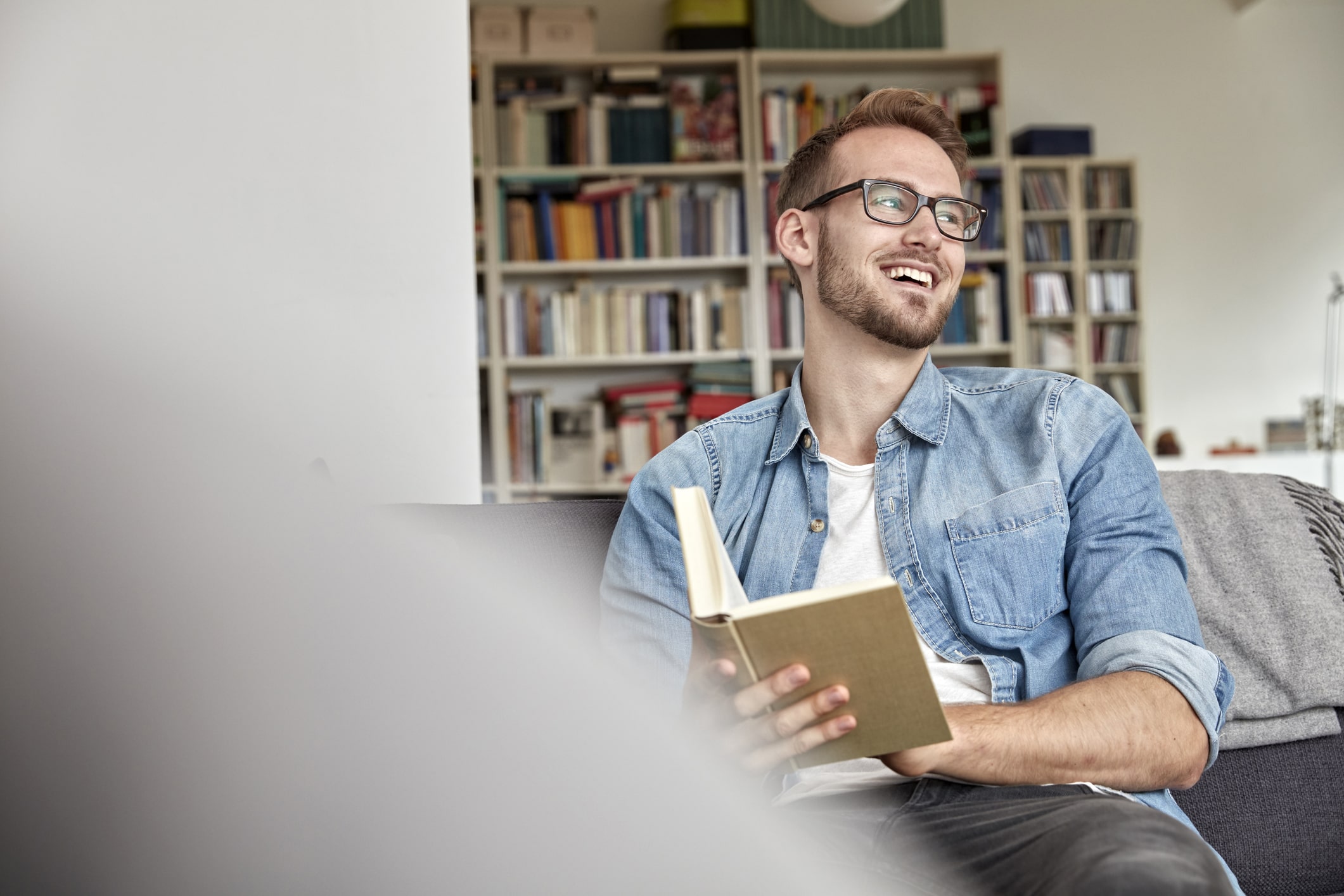 Laughing-man-sitting-with-book-benefits-of-knowing-yourself