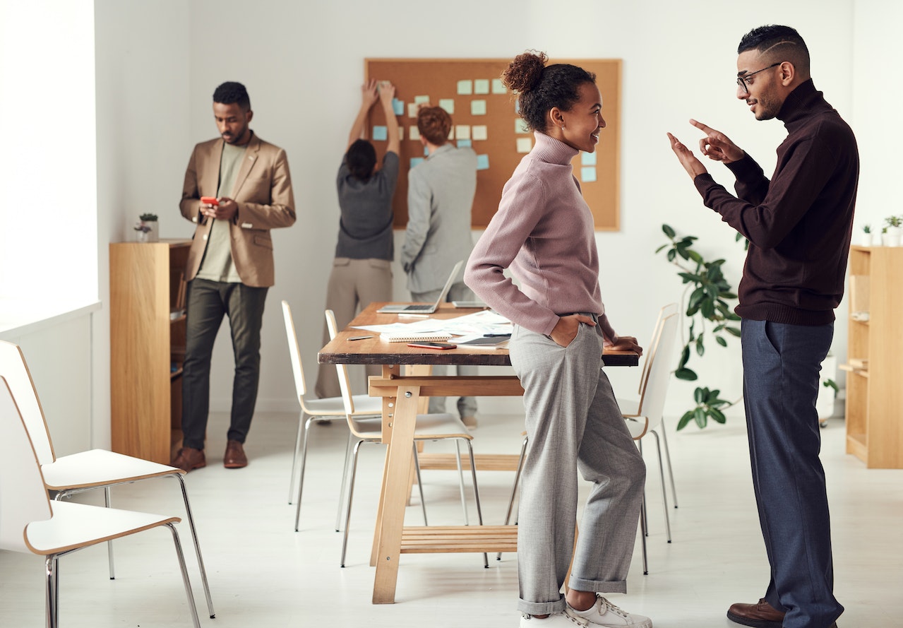 Man-and-woman-coworkers-talking-friendly-at-break-room-negotiation-skills