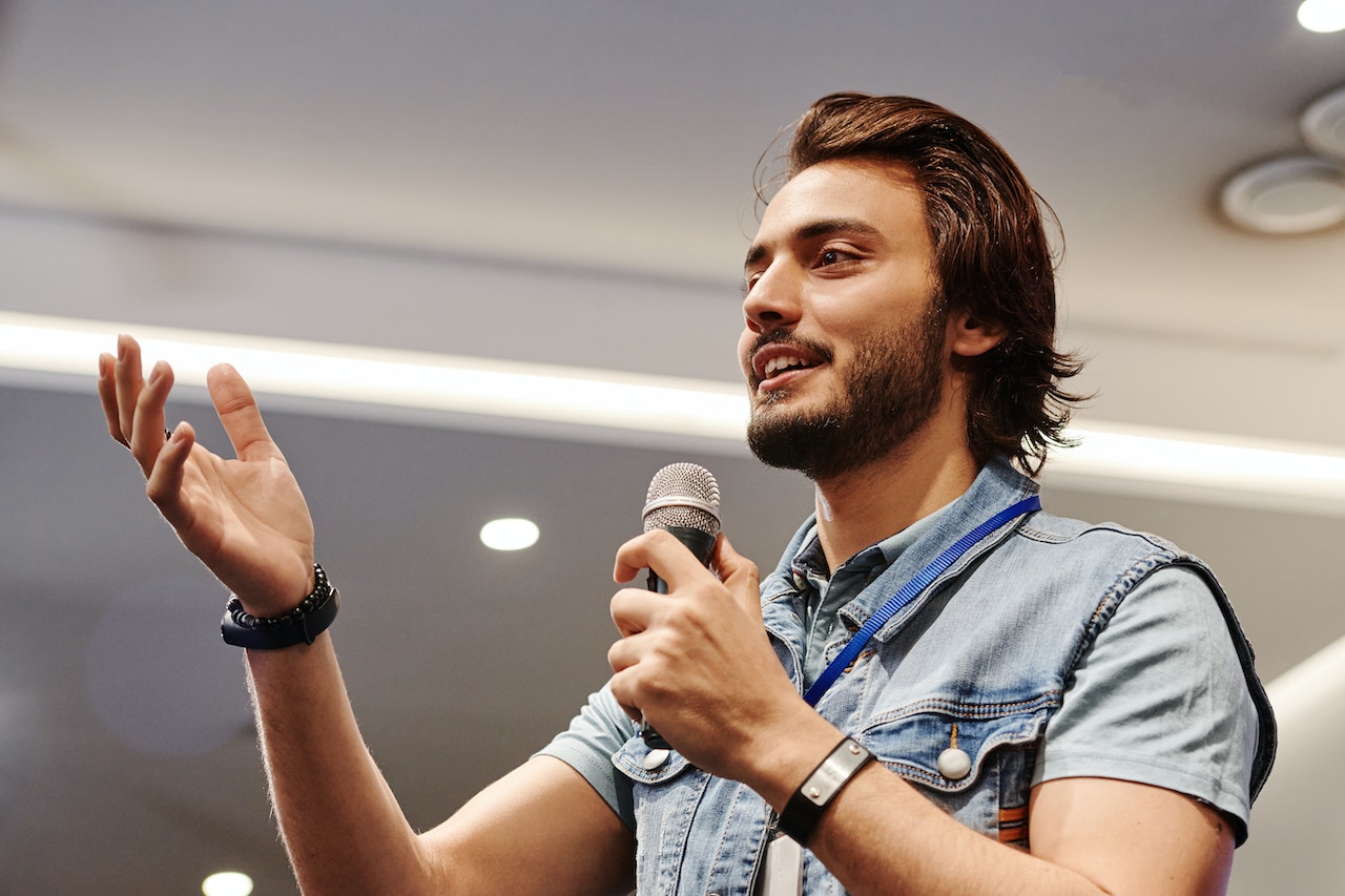 Man-holding-microphone-while-speaking-in-public-how-to-give-a-speech