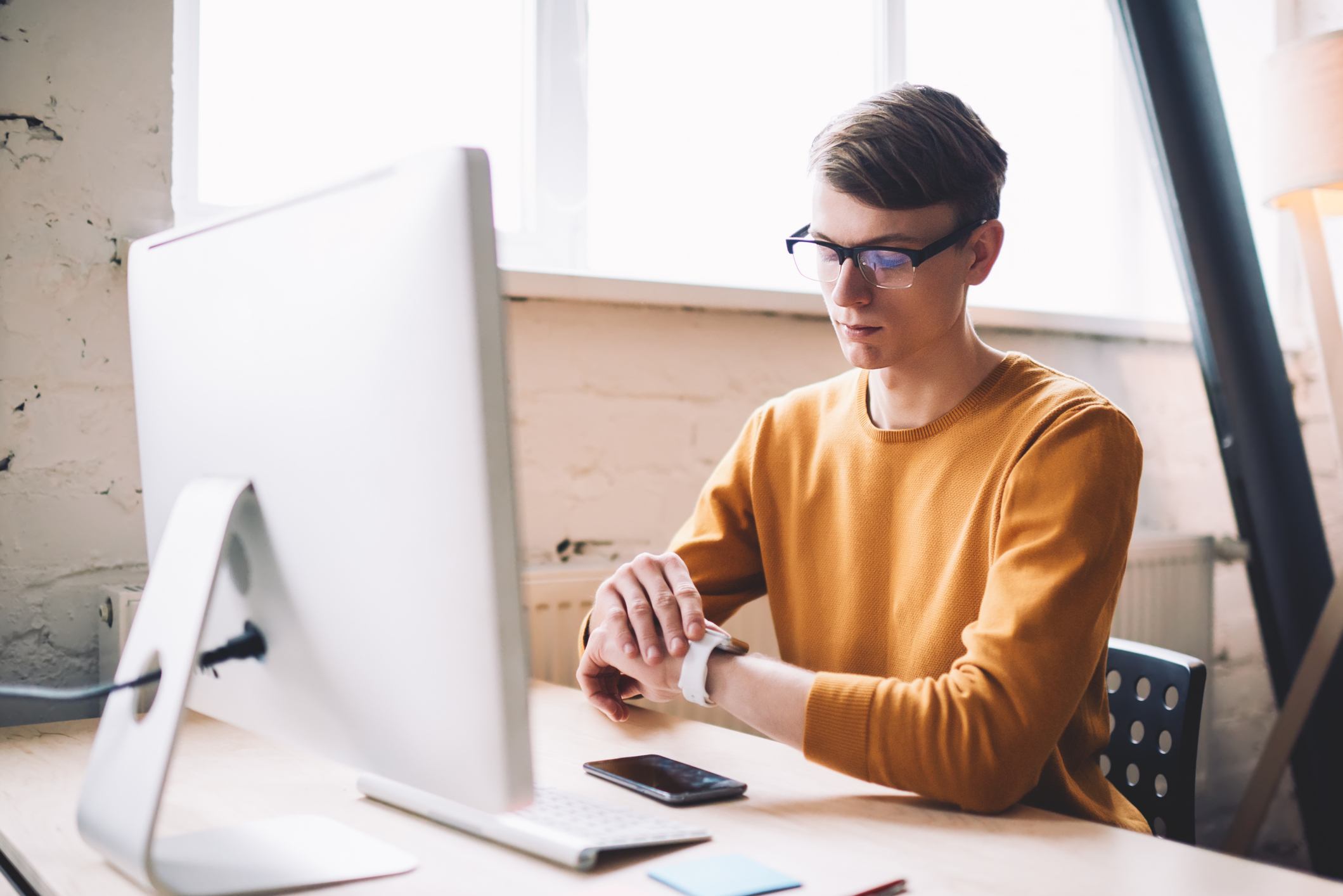 Man-looking-at-his-watch-at-office-examples-of-behavioral-goals