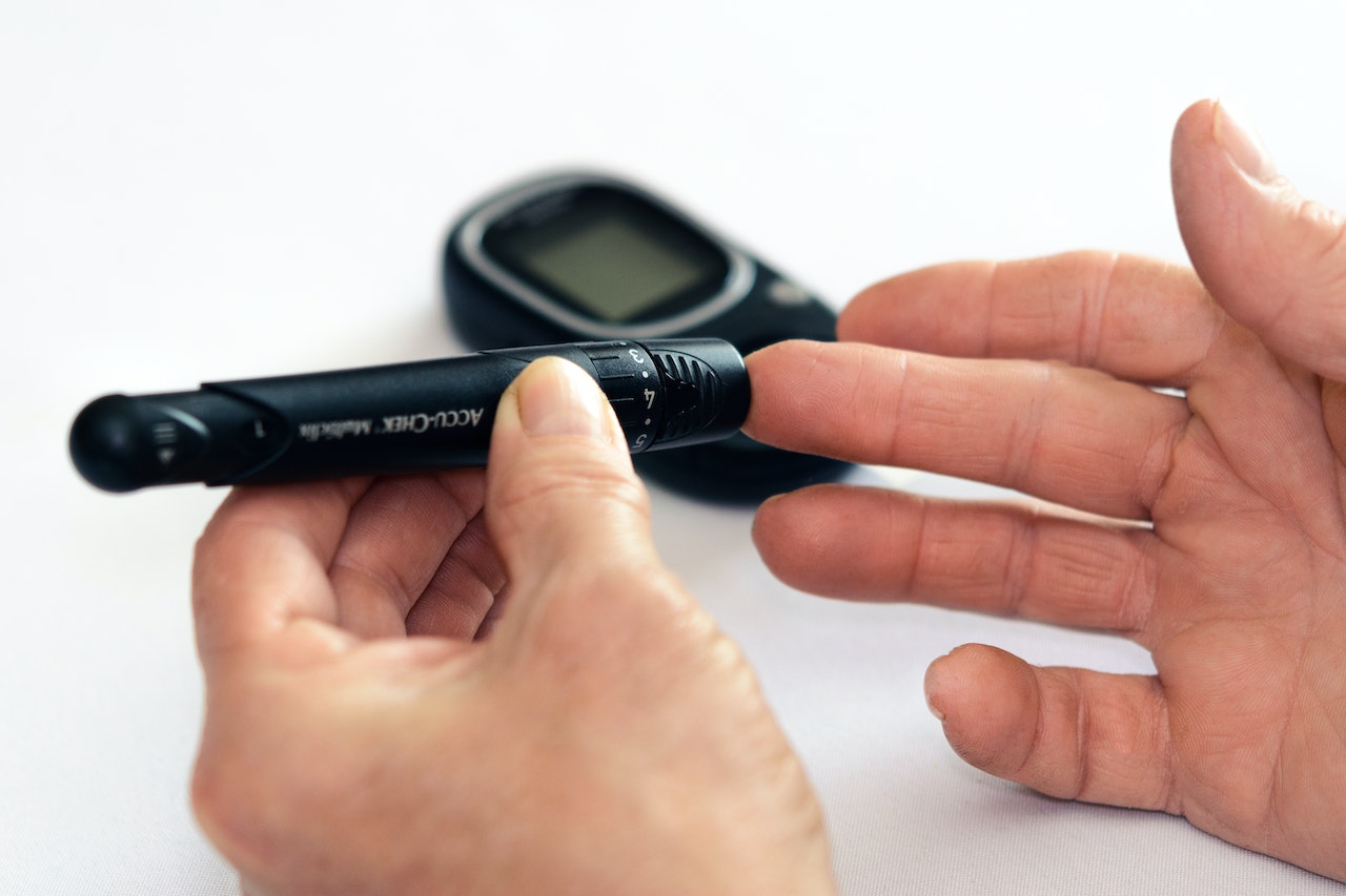 Man-pinching-his-finger-with-glucose-tracking-device-What-Happens-If-You-Sleep-Too-Much