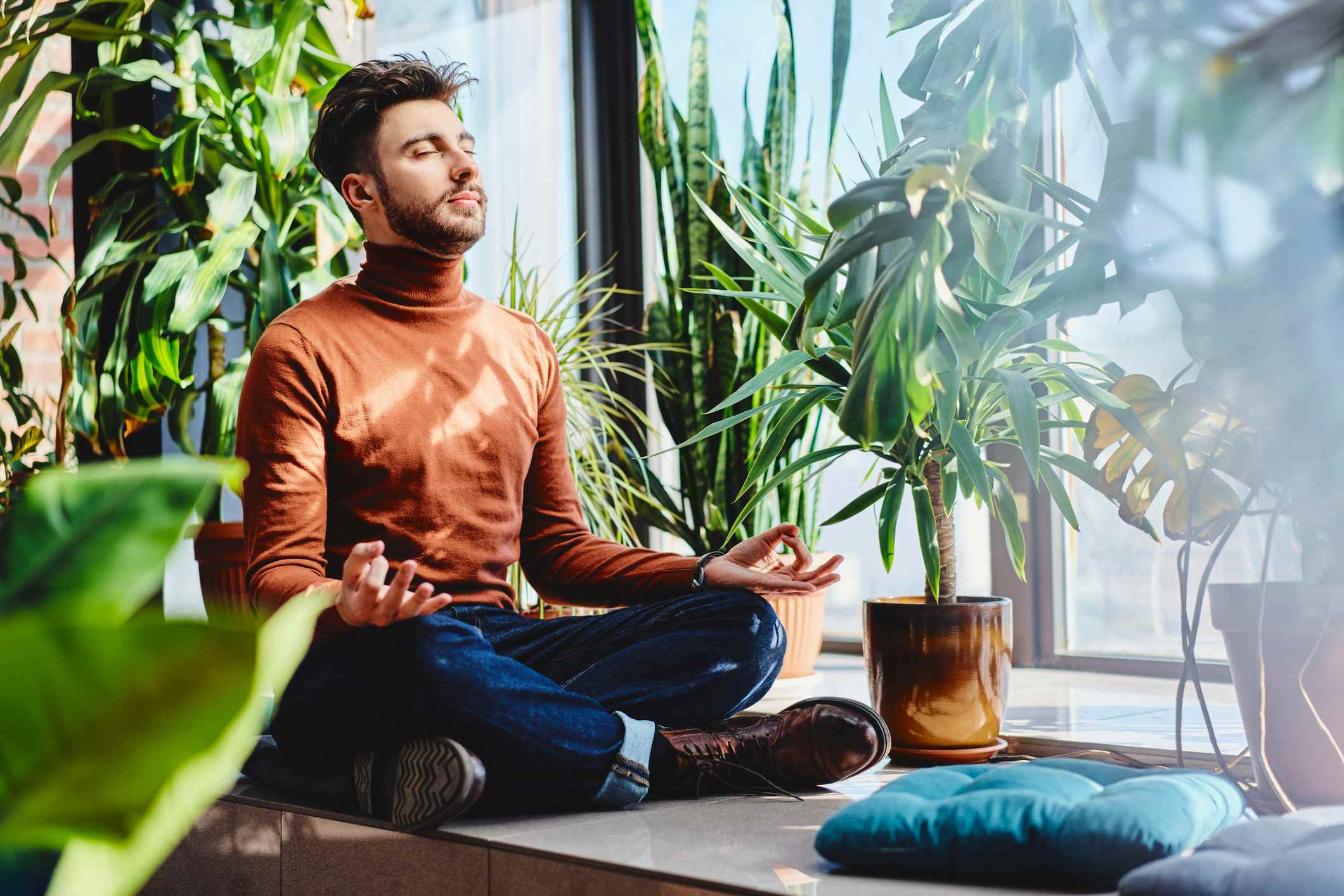 Man-sitting-cross-legged-while-meditating-how-to-focus-on-yourself