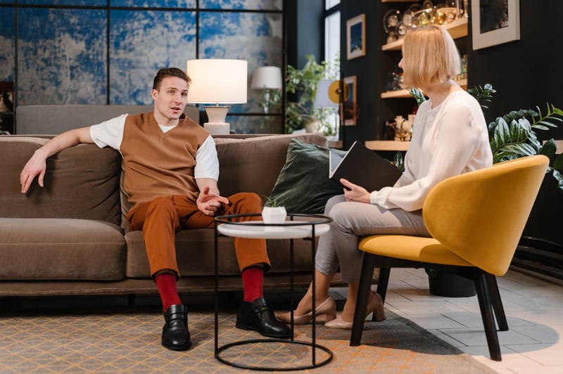 Man-speaking-to-psychologist-during-appointment-at-office