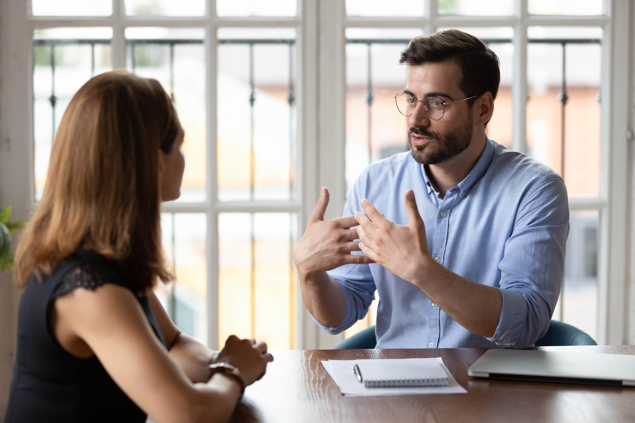 Man-talking-to-his-manager-at-office-signs-your-coworker-is-threatened-by-you-and-how-to-deal-with-it