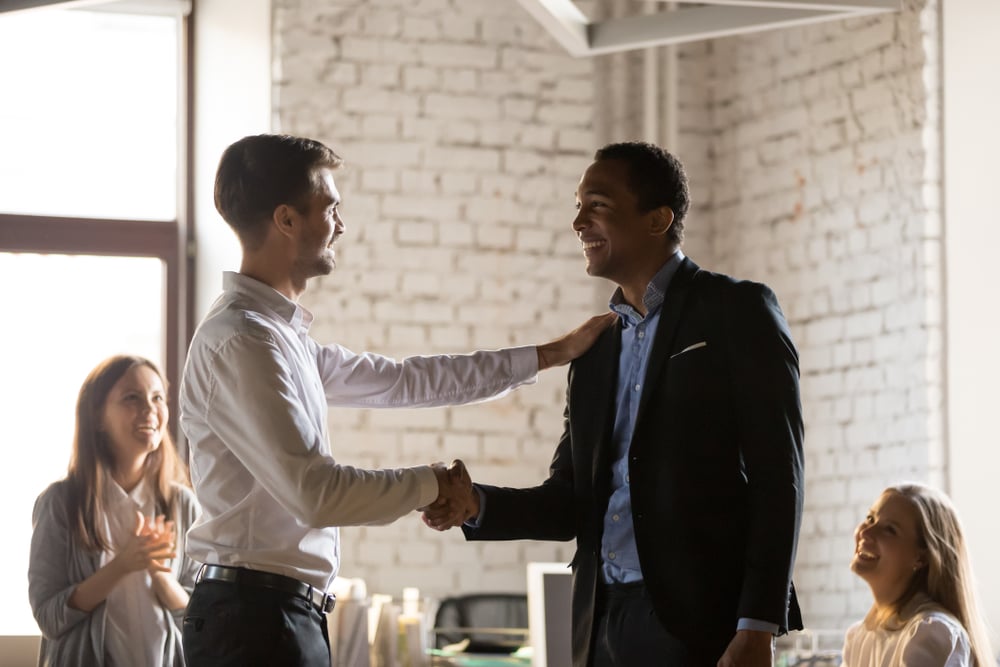 Men-congratulating-another-men-in-a-meeting-how-to-overcome-lack-of-ambition