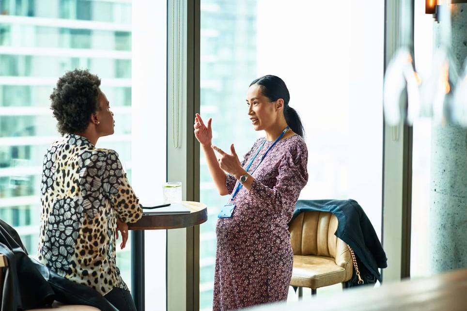 Pregnant-woman-gesturing-and-explaining-to-colleague-how-to-hold-yourself-accountable