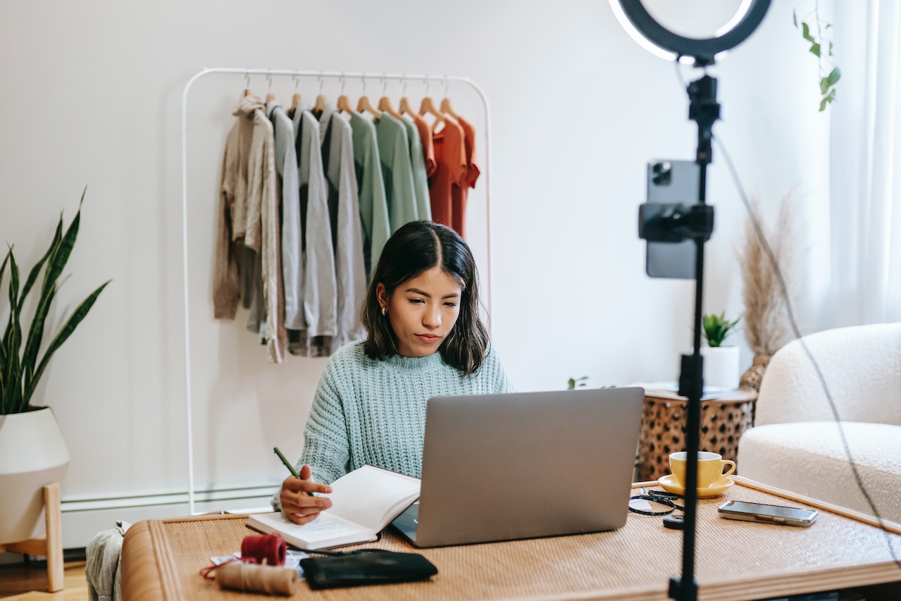 Social-media-manager-using-laptop-and-writing-on-notebook-in-front-of-ring-light-how-to-get-a-job-with-no-experience