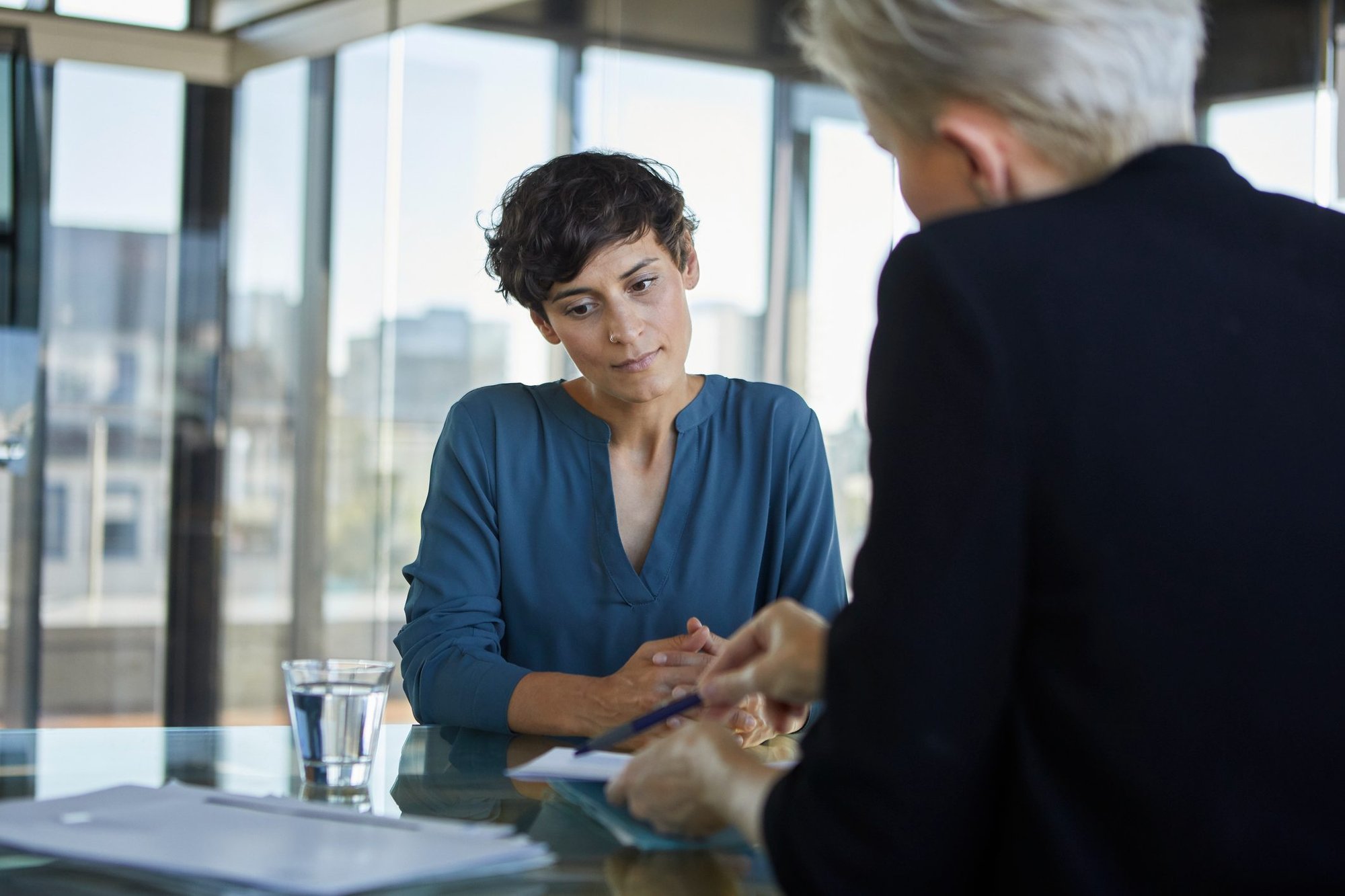 Two-businesswomen-talking-at-desk-in-office-bad-at-job-interviews