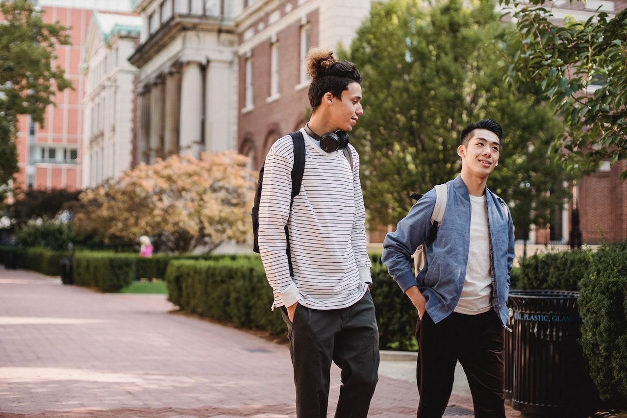 Two-men-walking-down-street-at-college-talking-deep-questions-to-ask