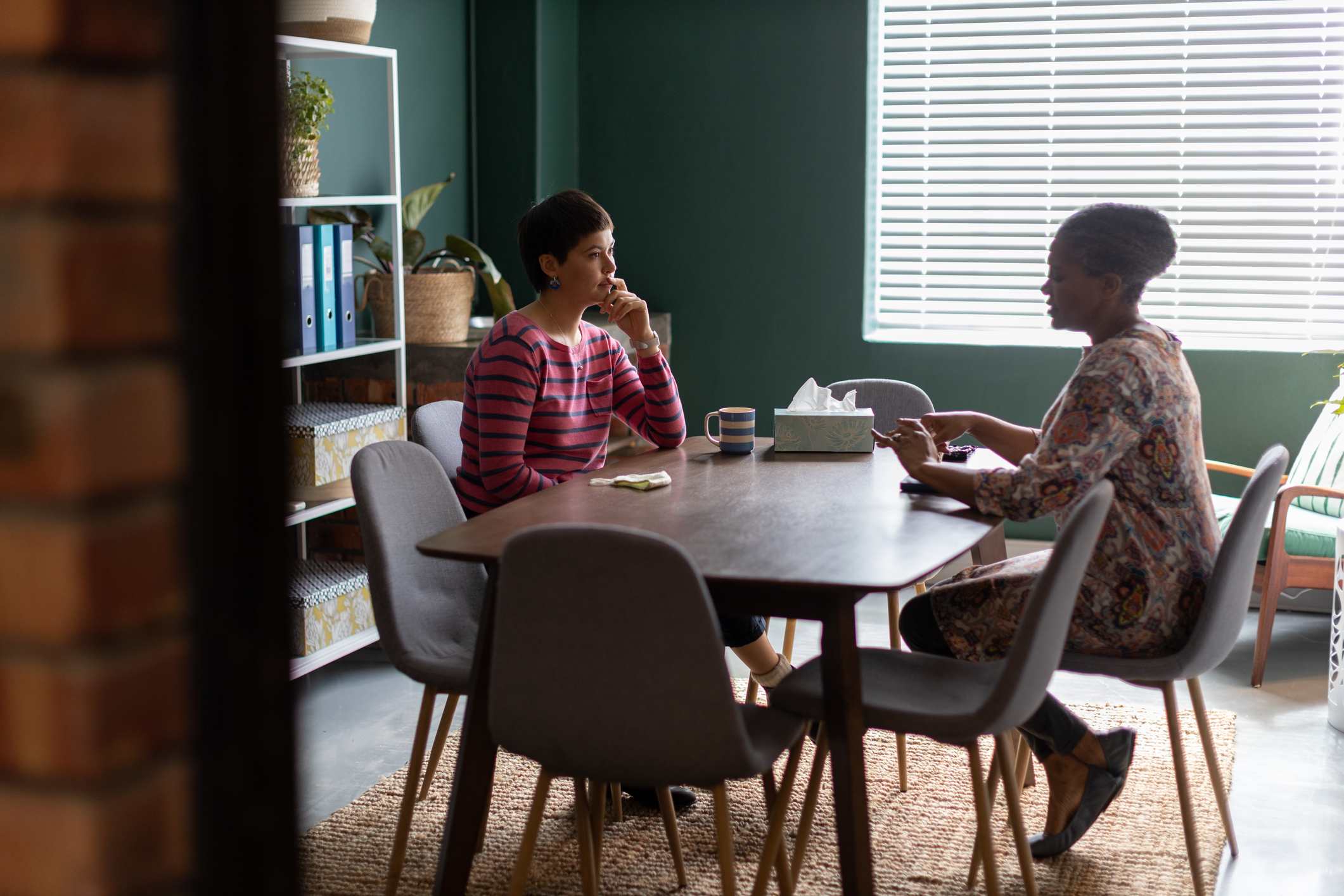 Two-women-talking-at-counselling-session-in-an-office-boardroom-active-listening