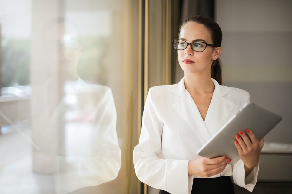 Woman-Holding-a-Tablet-While-Looking-Outside-a-Window-resignation-letter