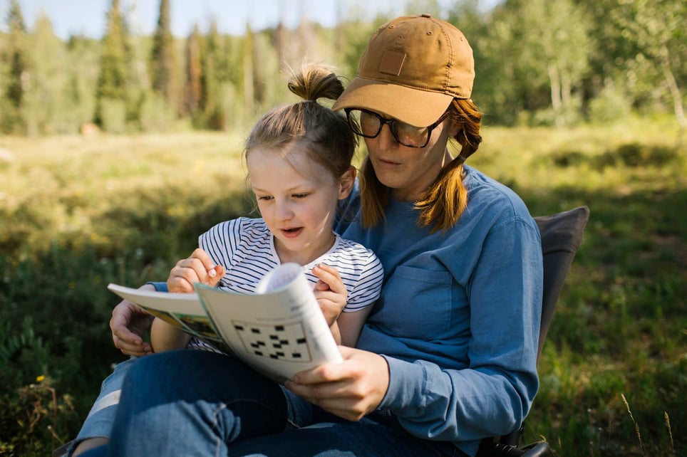 Woman-holding-her-toddler-outdoors-while-doing-crossword-how-to-improve-memory