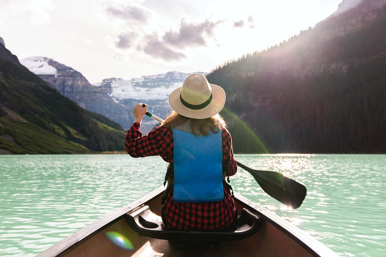 Woman-in-beautiful-river-in-the-mountains-in-a-canoe-unique-employee-benefits
