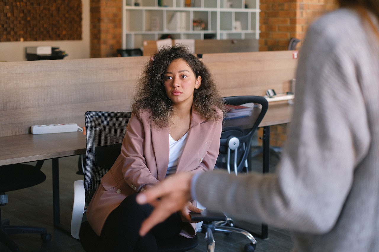 Woman-listening-to-coworker-talking-salary-negotiation-tips
