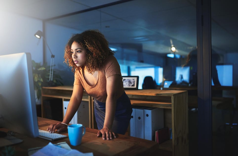 Woman-looking-at-computer-at-her-office-in-night-shift-how-to-adjust-to-night-shifts