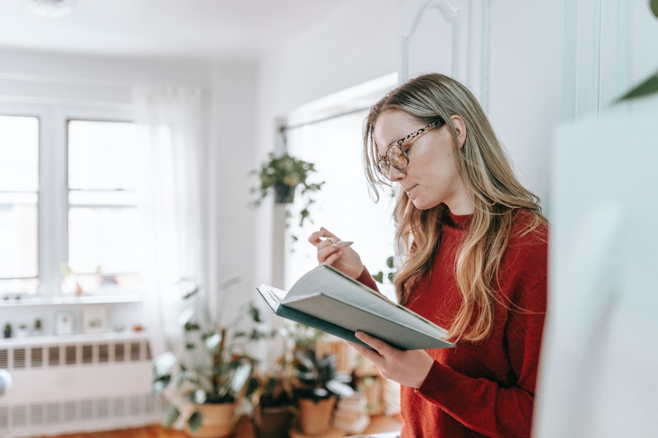 Woman-reading-a-book-while-eating-yogurt-at-home-10-year-plan-examples