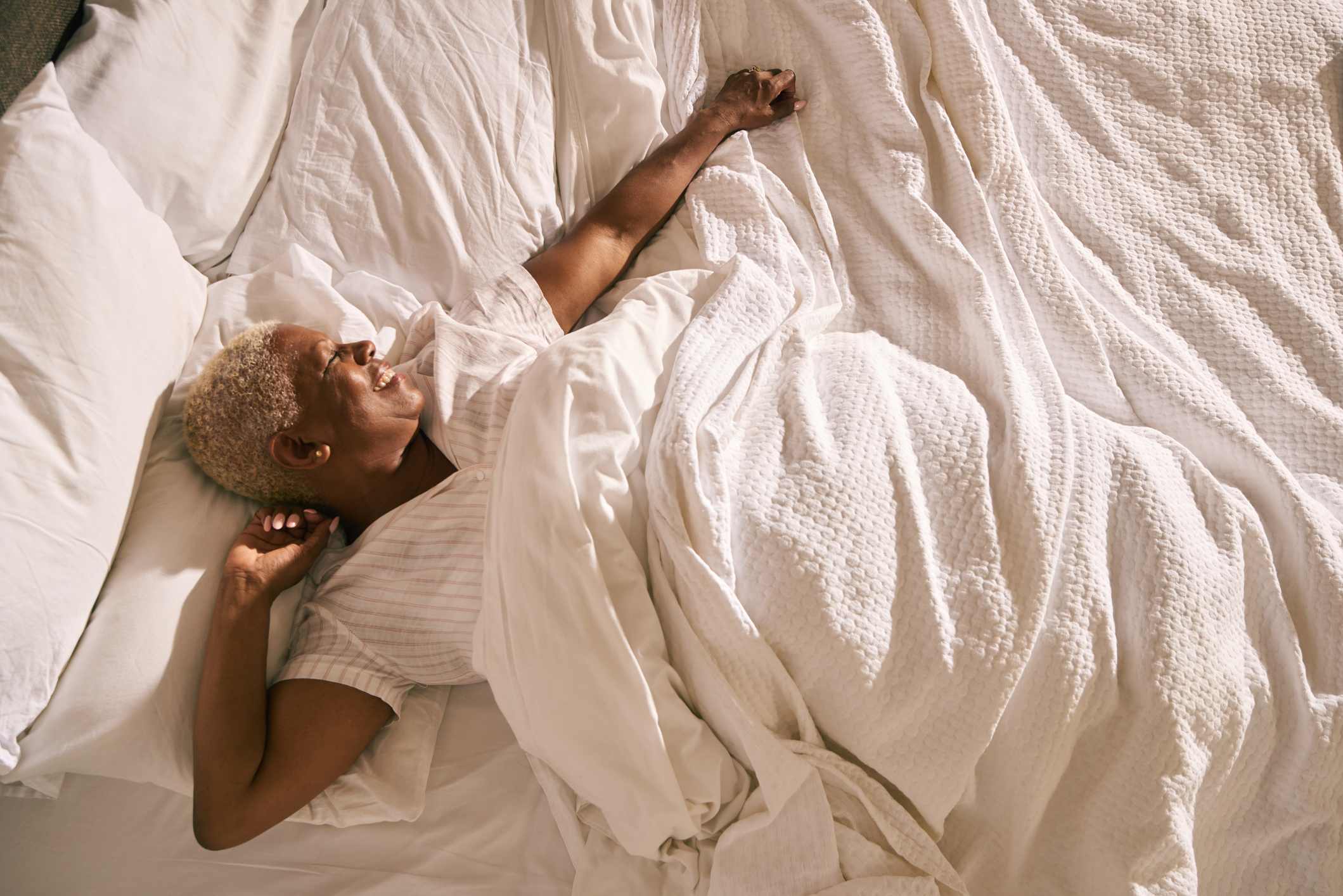 Woman-smiling-right-after-waking-up-in-her-bed-how-to-improve-memory