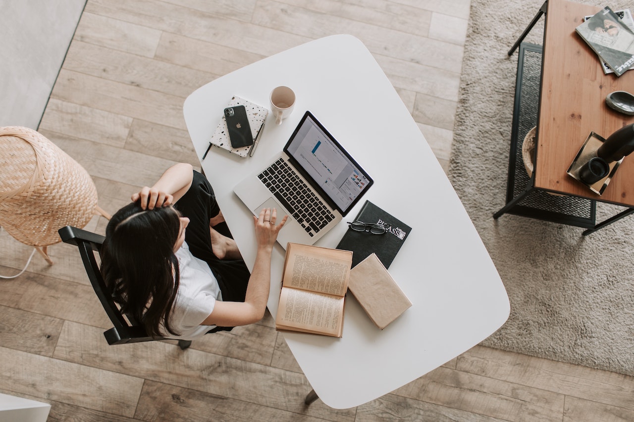 Woman-solving-work-problem-from-home-with-laptop-and-books-negotiation-skills