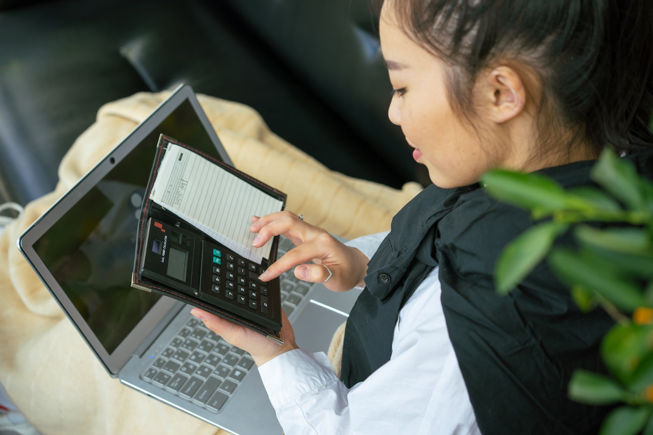 Woman-using-calculator-and-laptop-to-pay-taxes-stipend-vs-salary