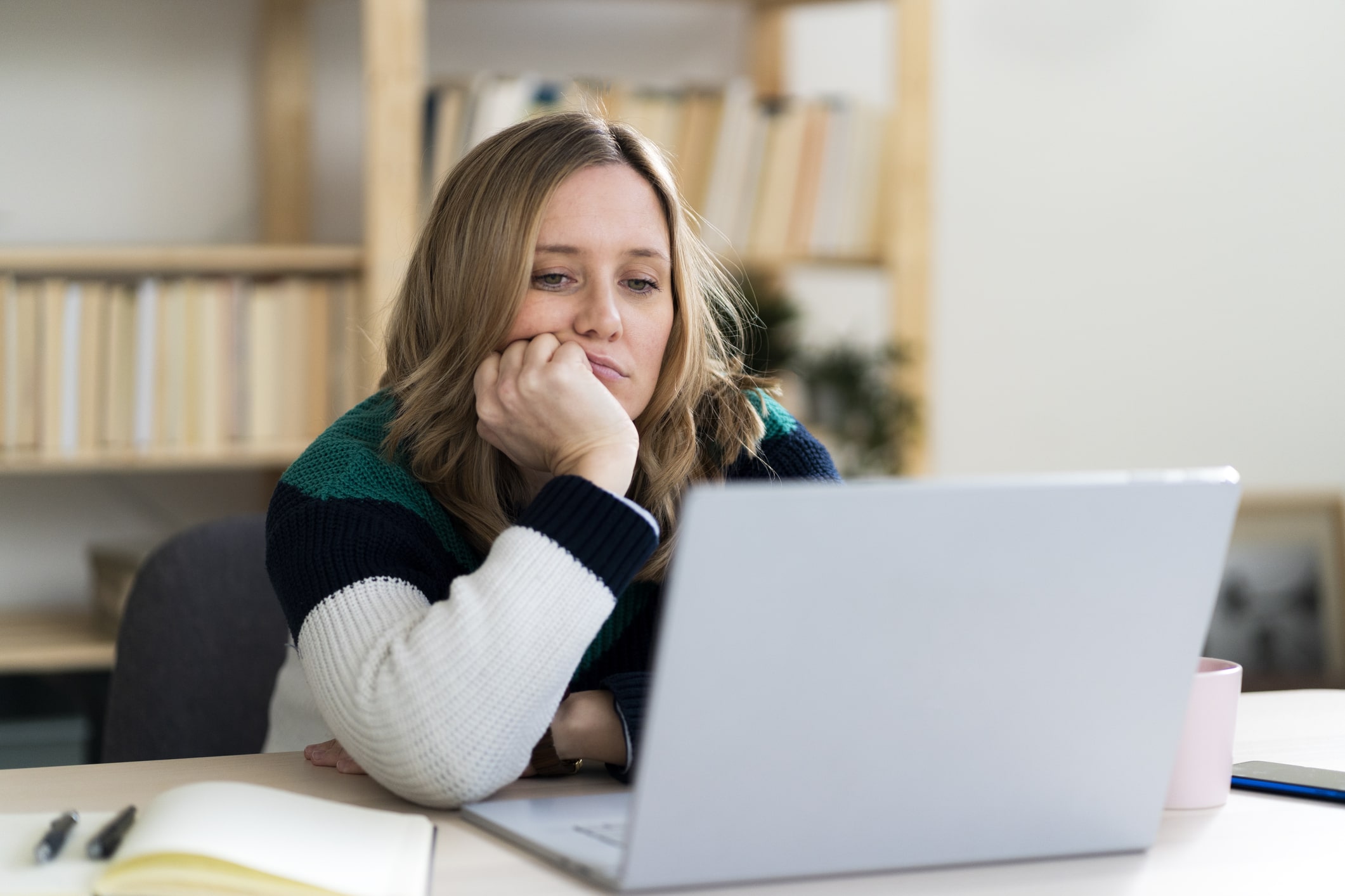 Woman-with-hand-on-chin-staring-at-laptop-cant-i-focus-on-anything