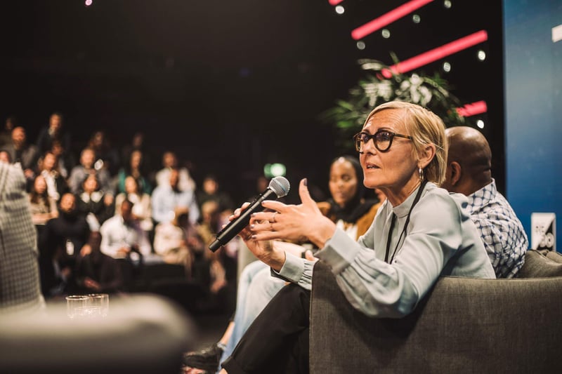 Woman-with-microphone-speaking-at-a-conference-communications-degree-jobs