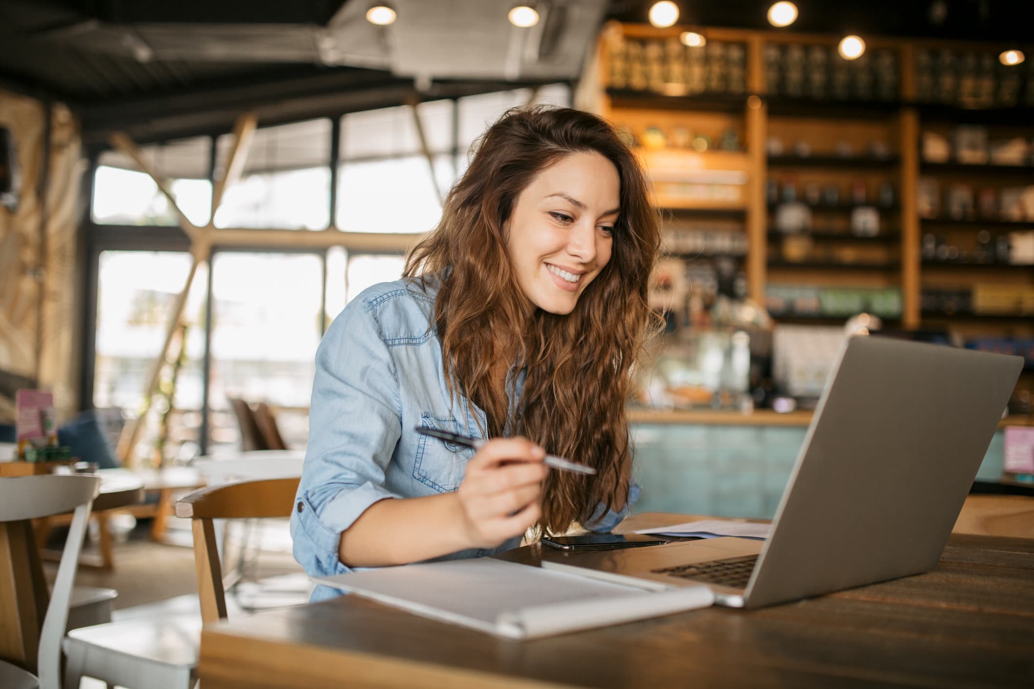 Woman-writing-an-email-at-a-cafe-strong-communications-skills