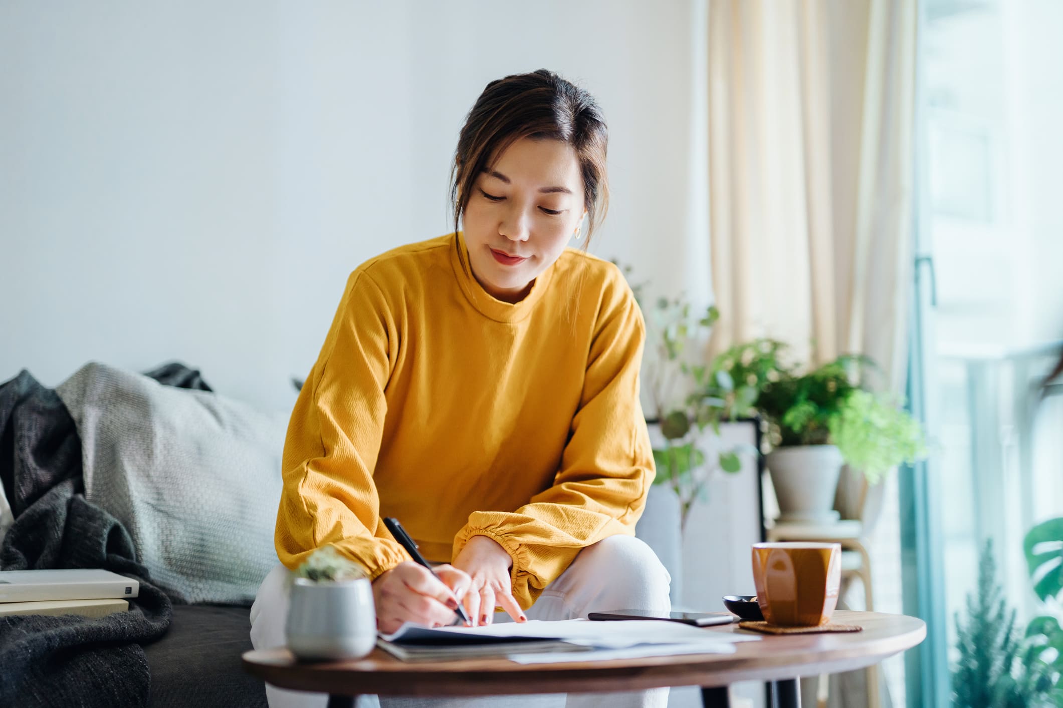 Woman-writing-on-a-notebook-by-hand-strong-communications-skills