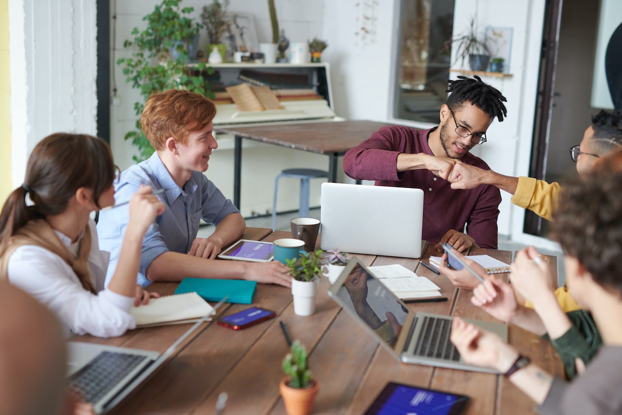Work-collegues-giving-high-five-while-in-meeting-unique-employee-benefits