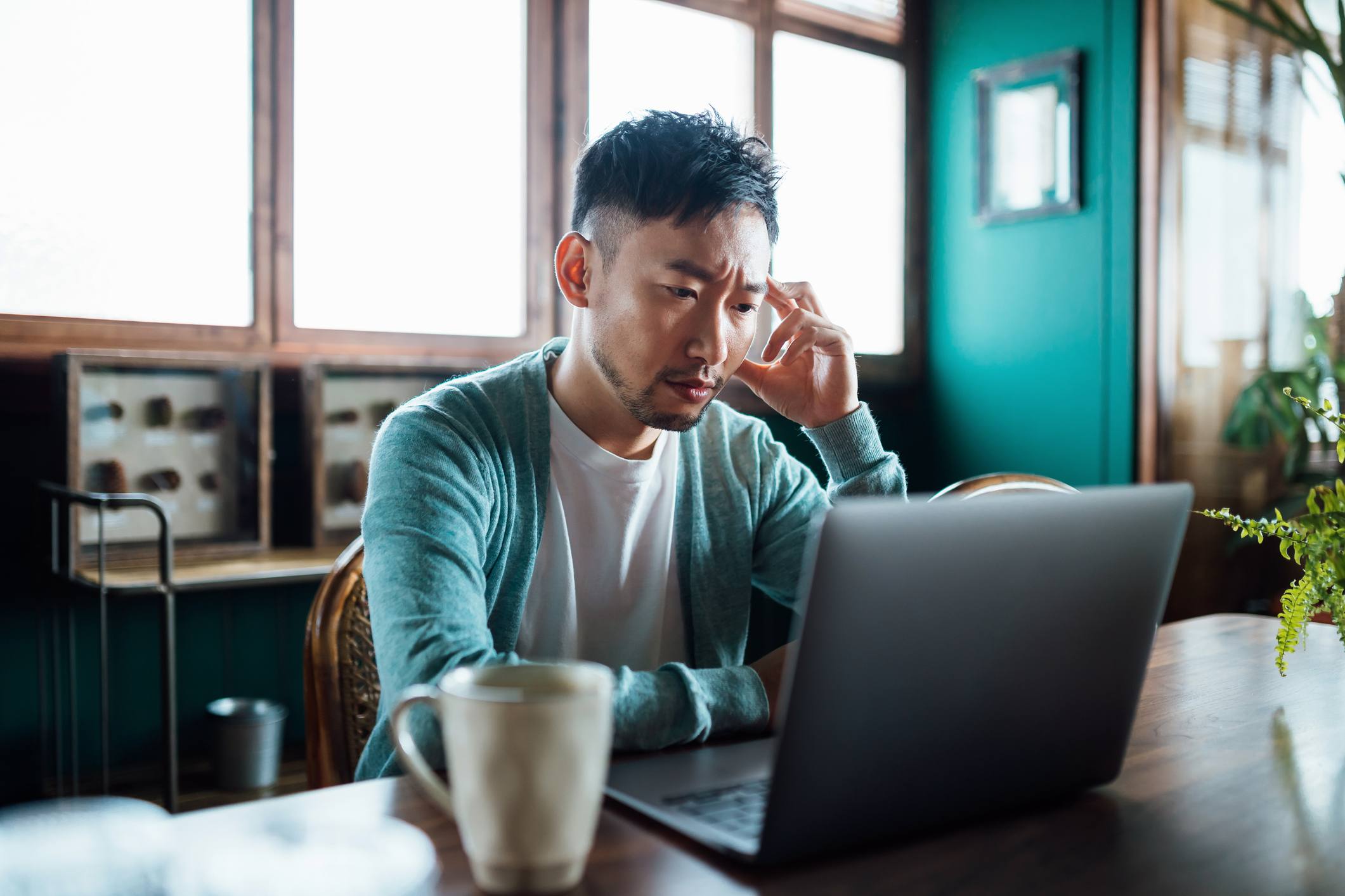 Worried-young-Asian-man-with-his-hand-on-head-fast-paced-environment