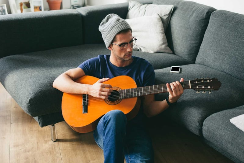 Young-Man-Playing-Guitar-At-Home-how-to-become-smarter