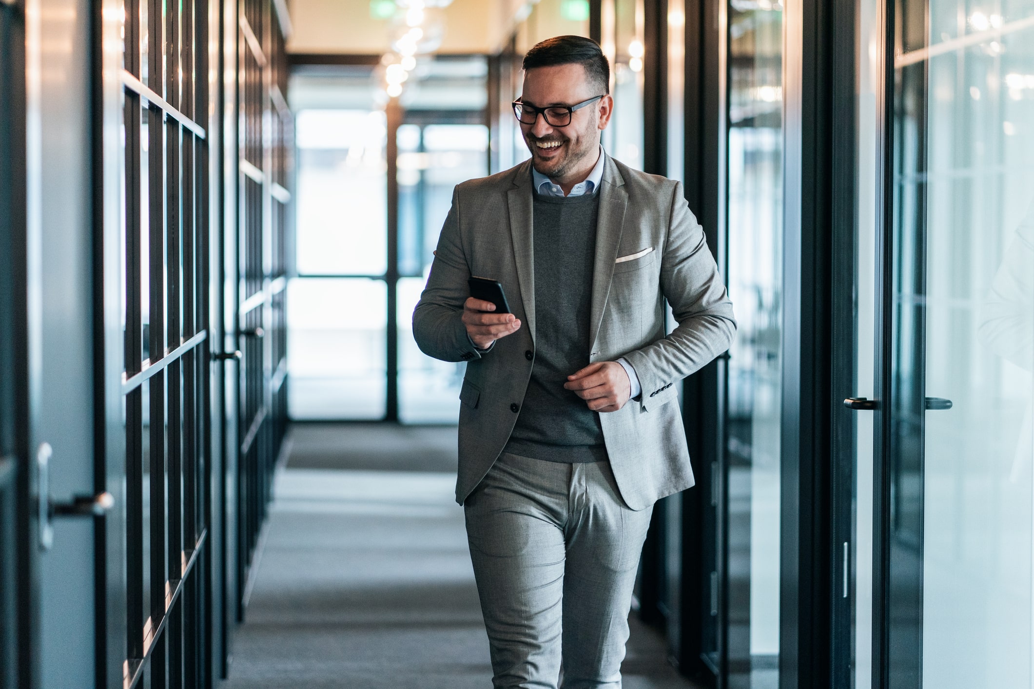 businessman-texting-and-smiling-at-office-resilient-mindset