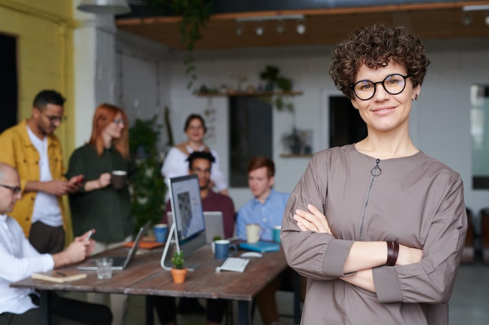 female-leader-smiling-with-team-in-the-background-relational-leadership-model