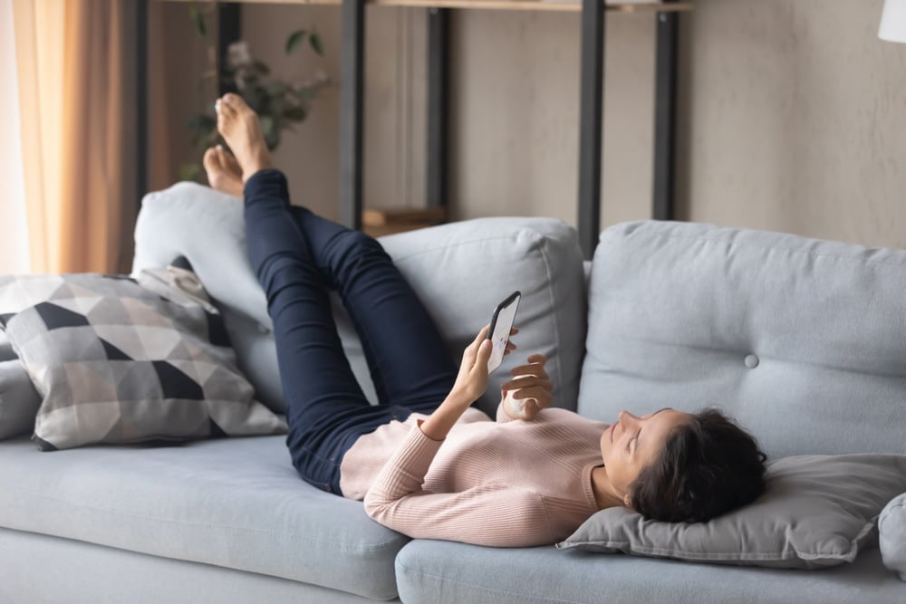 girl-relaxing-on-her-couch-with-her-phone-self-care-for-caregivers